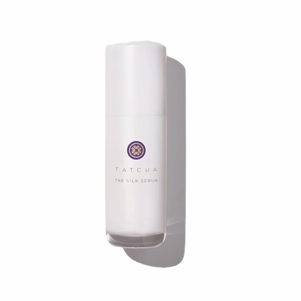 Tatcha The Silk Serum in sleek white bottle with gold and purple emblem